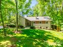 Beautifully landscaped two-story home with brick accents, surrounded by mature trees and lush greenery at 5719 Doncaster Dr, Charlotte, NC 28211