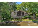 Exterior view of home with screened porch overlooking a peaceful pond at 5915 Mammoth Rd, Charlotte, NC 28270