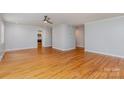 Open-concept living area showcasing hardwood floors, neutral walls, a ceiling fan, and easy access to the kitchen at 6007 Charing Pl, Charlotte, NC 28211