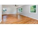 Bright living room with large windows, classic hardwood floors, and neutral paint providing a welcoming atmosphere at 6007 Charing Pl, Charlotte, NC 28211