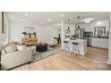 Open concept living room with modern decor and a breakfast bar with stools at 6706 Queensberry Dr, Charlotte, NC 28226