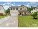 Charming two-story home featuring a spacious lawn, a two-car garage, and a welcoming front porch at 7031 Woodbridge Valley Cir, Charlotte, NC 28227