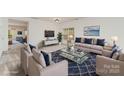 Bright living room is virtually staged with neutral colors and a calming blue accent decor at 7031 Woodbridge Valley Cir, Charlotte, NC 28227