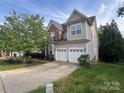 Spacious two-story home with a two-car garage, mature trees, and a well-maintained lawn at 715 Larimer Ln, Charlotte, NC 28262