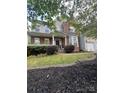 Charming home exterior with a welcoming front porch, manicured landscaping, and brick accents at 715 Larimer Ln, Charlotte, NC 28262
