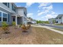 Street view of a charming two-story home featuring a manicured lawn and inviting entrance at 725 Pointe Andrews Dr, Concord, NC 28025
