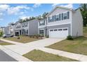 Street view of a charming neighborhood featuring well-maintained homes with two-car garages at 725 Pointe Andrews Dr, Concord, NC 28025