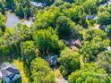 An aerial view of a beautiful home with lush, mature trees and a scenic lake nearby in a serene neighborhood at 8017 Nathanael Greene Ln, Charlotte, NC 28227