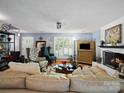 A well-lit living room showcases hardwood floors, plush furniture, a white painted fireplace, and decorative lighting at 8017 Nathanael Greene Ln, Charlotte, NC 28227