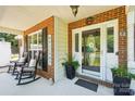 Inviting front porch with rocking chairs, brick accents, and a welcoming entrance for guests and homeowners at 8056 Stevens Mill Rd, Matthews, NC 28104