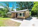 Quaint brick home boasts classic curb appeal, showcasing its inviting facade and manicured landscaping at 8303 Hemby Wood Dr, Indian Trail, NC 28079
