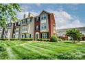 Beautiful townhome exterior featuring a lush lawn and sidewalk leading to the front door at 9204 Washam Potts Rd, Cornelius, NC 28031