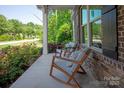 Inviting front porch featuring cozy seating, stone accents, and a view of the landscaped yard at 938 Rock Forest Way, Fort Mill, SC 29707