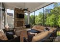 Inviting screened porch with stone fireplace, ceiling fan, comfortable seating, and outdoor TV for relaxation at 1148 Wessington Manor Ln, Fort Mill, SC 29715