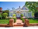 Charming historic home with mature landscaping, brick entry and walkway, and inviting front porch at 116 N Mulberry St, Statesville, NC 28677