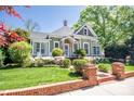 Charming historic home with mature landscaping, brick entry and walkway, and inviting front porch at 116 N Mulberry St, Statesville, NC 28677