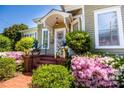 Inviting front porch with brick steps, lush azaleas, and a decorative security door at 116 N Mulberry St, Statesville, NC 28677