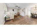 Bright living room featuring wood flooring, staircase, ceiling fan, and plenty of natural light at 12536 Hennigan Place Ln, Charlotte, NC 28214