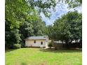 Spacious backyard featuring a detached garage with lush green grass and mature trees at 165 Graceland Pl, Salisbury, NC 28146