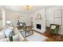 Inviting living room with a white painted brick fireplace and hardwood floors at 1804 Thomas Ave, Charlotte, NC 28205