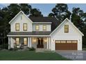Charming two-story home with a covered porch, inviting entrance, and a two-car garage at 1807 Kennesaw Dr, Charlotte, NC 28216