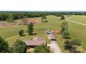 Aerial shot of a property featuring a brick home with a detached garage, additional structure, and open land at 1870 Sloan Rd, Mt Ulla, NC 28125