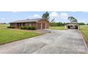 Exterior angle showcasing the brick home with two-car garage and a large detached garage with ample driveway space at 1870 Sloan Rd, Mt Ulla, NC 28125