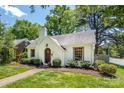 Lovely white Tudor-style home featuring a manicured lawn and welcoming front entrance at 2033 Charlotte Dr, Charlotte, NC 28203
