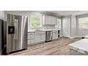 Modern kitchen with stainless steel appliances, white cabinets, marble countertops, and wood-look flooring at 2322 Hedgewood Cir, Gastonia, NC 28052