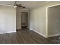 Well-lit living room featuring laminate flooring, neutral paint, modern ceiling fan, and white trim at 2322 Hedgewood Cir, Gastonia, NC 28052