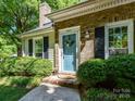 Inviting front entrance with a light blue door, decorative wreath, and manicured shrubs at 2401 Birnen Dr, Charlotte, NC 28210