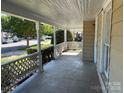 Inviting covered front porch with white railing, offering a relaxing outdoor space with views of neighborhood at 2433 Booker Ave, Charlotte, NC 28216