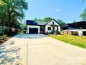 Beautiful new construction home showcasing white siding, a black roof, large driveway, and professionally landscaped yard at 2907 Lake Ave, Charlotte, NC 28208