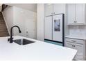 Bright kitchen featuring white cabinets, modern appliances, a large island, and a view towards the stairs at 3252 Cheyney Park Dr, Charlotte, NC 28269