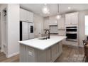 Modern kitchen with an island, white cabinets, stainless steel appliances, marble backsplash, and stylish pendant lighting at 3252 Cheyney Park Dr, Charlotte, NC 28269