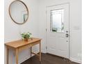 Bright entryway featuring a wood table with a leafy plant and a round mirror on the wall at 3618 Catherine Creek Pl, Davidson, NC 28036