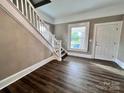 A home entryway features wood-look floors, a staircase with white railing, and a door leading to the outside at 419 S Spencer Ave, Spencer, NC 28159