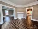 Bright living room featuring elegant dark wood floors, a decorative fireplace, and entryways leading to other spaces at 419 S Spencer Ave, Spencer, NC 28159