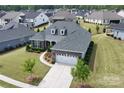 Aerial view of a beautiful home with a lush lawn and mature trees in a suburban neighborhood at 45523 Misty Bluff Dr, Charlotte, NC 28278