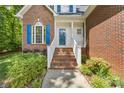 Inviting front entrance with brick steps, white railing, and a vibrant blue door at 4790 Cascade Ave, Rock Hill, SC 29732