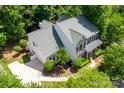 Aerial shot showcasing the house, the roof, the driveway, and the verdant trees at 6729 Garden Hill Dr, Huntersville, NC 28078