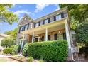 Attractive two-story brick home boasts black shutters, a covered porch, and lush green shrubbery at 6729 Garden Hill Dr, Huntersville, NC 28078
