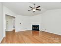 Bright living room featuring hardwood floors, fireplace, and ceiling fan at 9232 Four Mile Creek Rd, Charlotte, NC 28277
