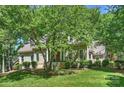 Lovely home exterior with lush landscaping and a covered front porch, shaded by mature trees at 9526 Greyson Ridge Dr, Charlotte, NC 28277