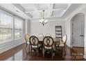 Dining room features a coffered ceiling, elegant chairs, and a modern chandelier, creating a sophisticated atmosphere at 1004 Craven St, Indian Trail, NC 28079