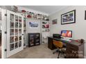 Home office with dark wood desk and a custom bookcase showcasing an extensive sports memorabilia collection at 1004 Craven St, Indian Trail, NC 28079
