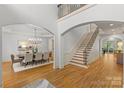 Grand foyer with staircase, hardwood floors and arched entryways to dining and living spaces at 1009 Seminole Dr, Waxhaw, NC 28173