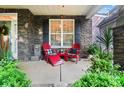 Cozy front porch with red Adirondack chairs, stone accents, and lush greenery at 10115 Paxton Run Rd, Charlotte, NC 28277