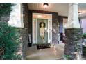 Inviting front porch with stone pillars, decorative wreath, and a welcoming atmosphere at 10115 Paxton Run Rd, Charlotte, NC 28277