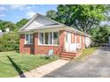 Cozy single-story brick home features a quaint front porch and an inviting entrance, set in a lush, green yard at 124 10Th Sw St, Conover, NC 28613